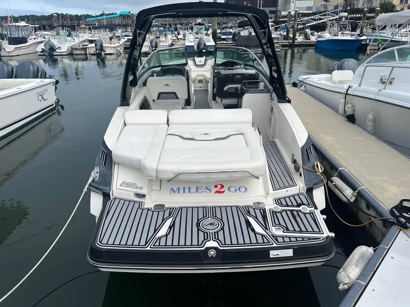 Slide: The Image of 2014 Monterey 288 SS boat docked at marina, rear view with Miles 2 Go text. - 16