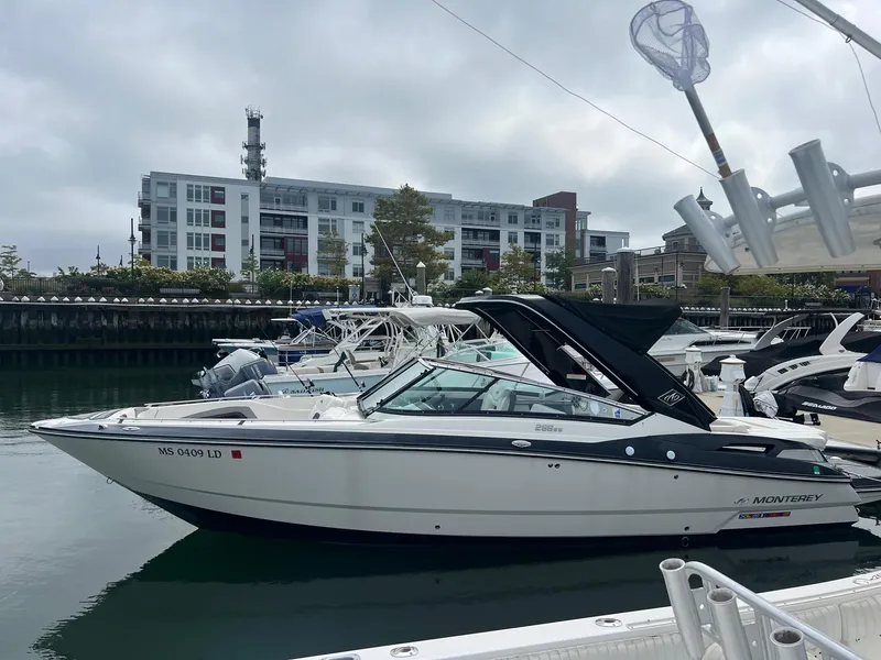 Slide: The Image of 2014 Monterey 288 SS boat docked at a marina with modern buildings in the background. - 17