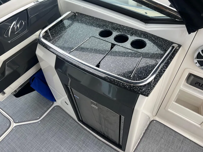 Slide: The Image of 2014 Monterey 288 SS boat interior with black speckled countertop and cup holders. - 24