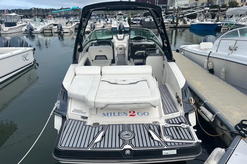 Slide: The Image of 2014 Monterey 288 SS boat docked at marina, rear view with Miles 2 Go text. - 31