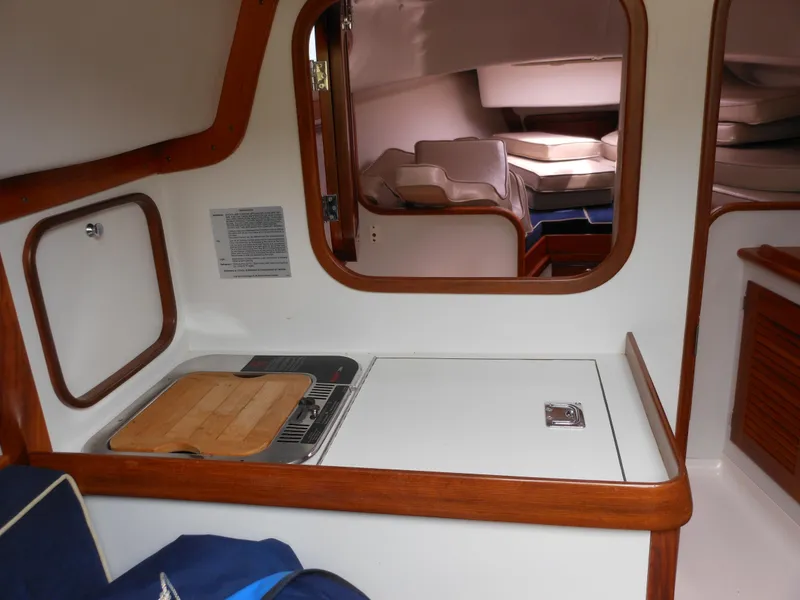 Slide: The Image of Interior of 2009 Alerion Express 33 sailboat, featuring compact kitchen and cozy cabin space. - 12