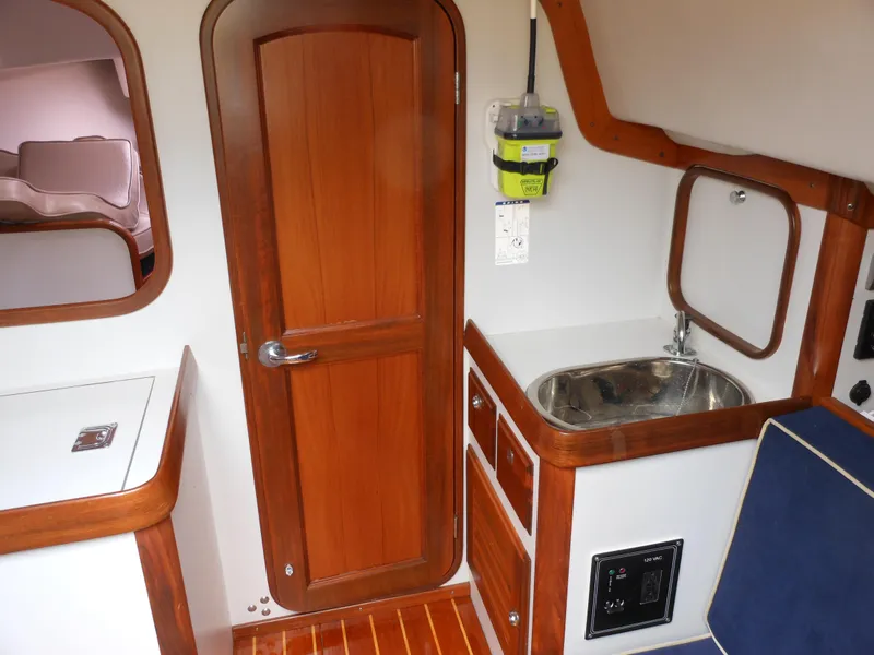 Slide: The Image of 2009 Alerion Express 33 interior with wooden door, sink, and cabinetry. - 17