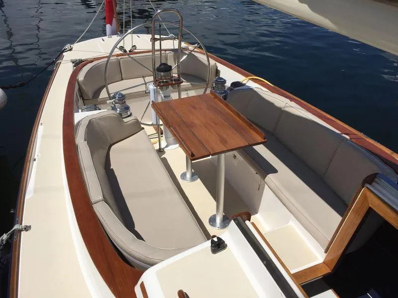 Slide: The Image of 2009 Alerion Express 33 sailboat cockpit with wooden table and cushioned seating. - 3
