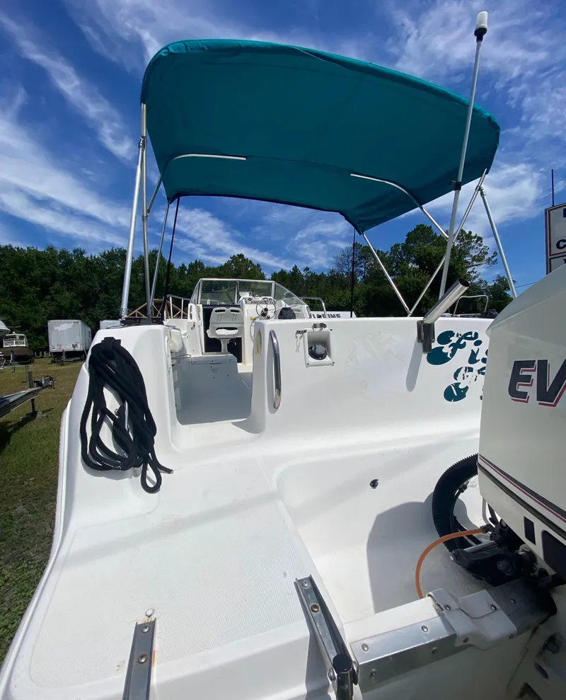 Slide: The Image of 1999 Aquasport 245 Explorer boat with blue canopy and Evinrude outboard motor. - 13