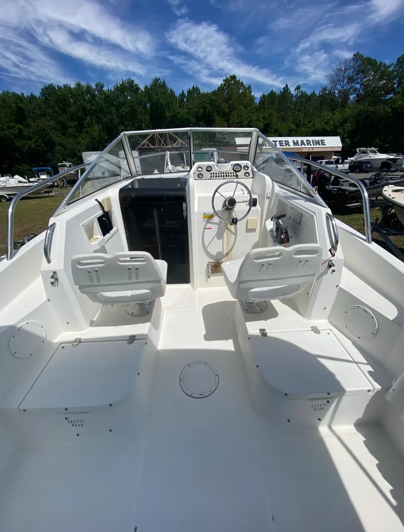 Slide: The Image of 1999 Aquasport 245 Explorer boat cockpit with dual seats and steering console. - 14