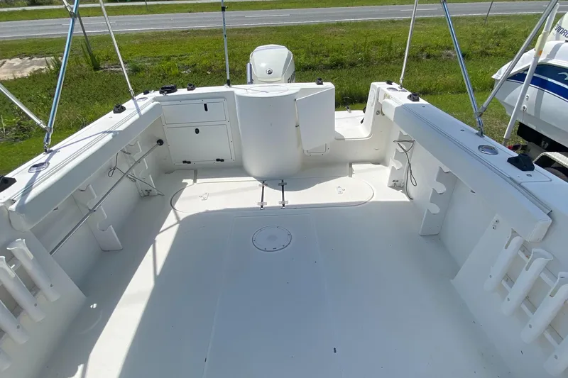 Slide: The Image of 1999 Aquasport 245 Explorer boat deck with storage compartments and rod holders. - 16