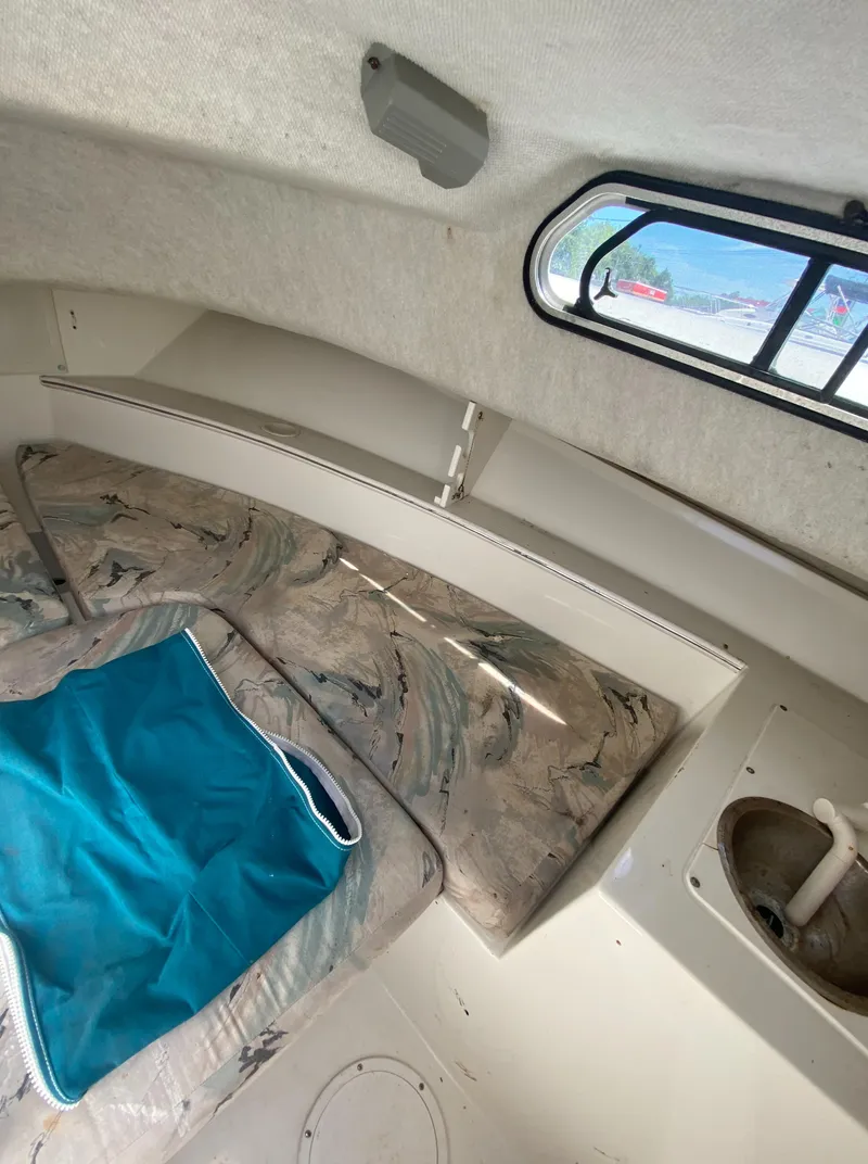 Slide: The Image of 1999 Aquasport 245 Explorer cabin interior with seating and window. - 22