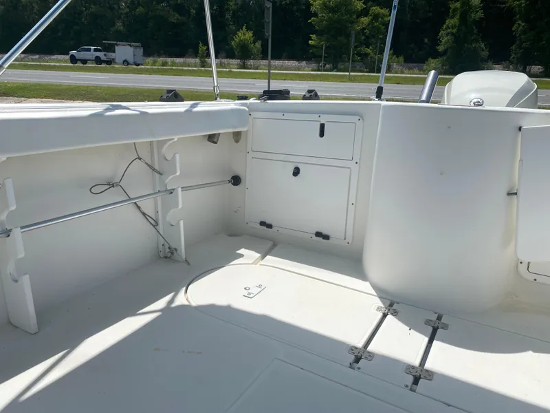 Slide: The Image of 1999 Aquasport 245 Explorer boat interior with storage compartments and rod holders. - 4