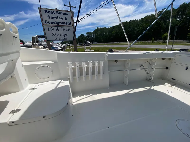 Slide: The Image of 1999 Aquasport 245 Explorer boat deck with rod holders and storage compartments. - 5