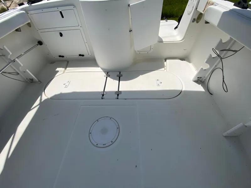 Slide: The Image of 1999 Aquasport 245 Explorer boat interior, spacious deck with storage compartments. - 6