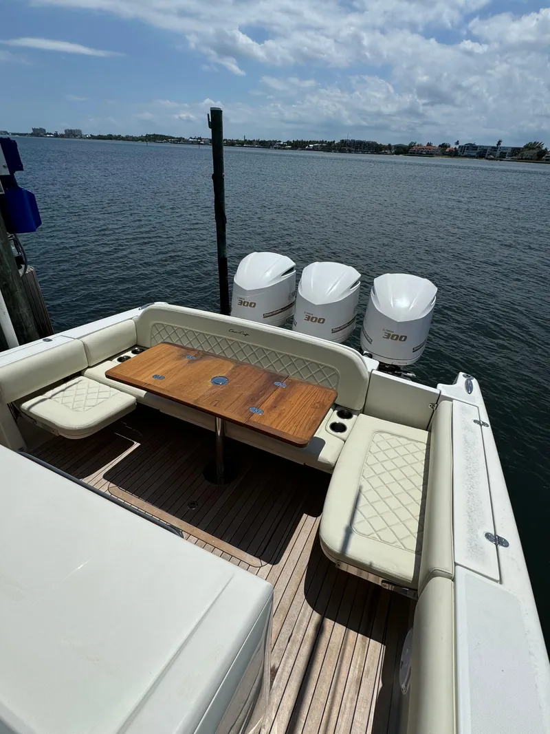 Slide: The Image of 2016 Chris-Craft Catalina 34 boat with triple outboard engines docked by the water. - 11