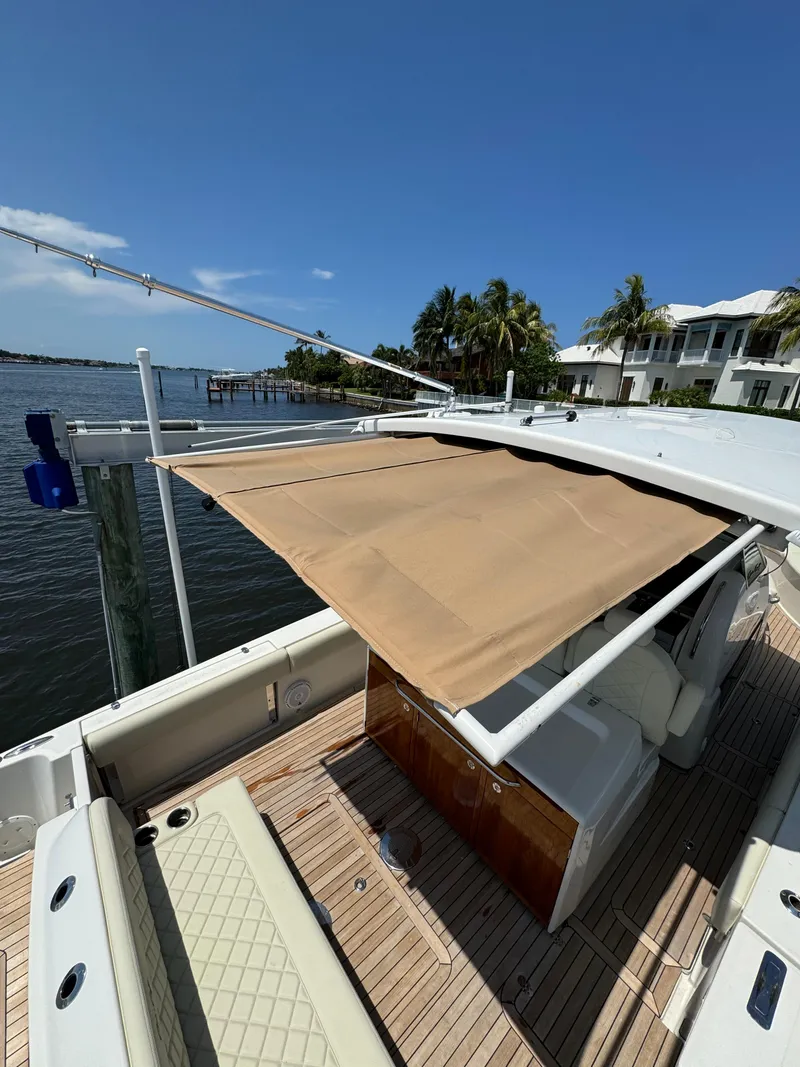 Slide: The Image of 2016 Chris-Craft Catalina 34 with extended sunshade docked by waterfront homes. - 15