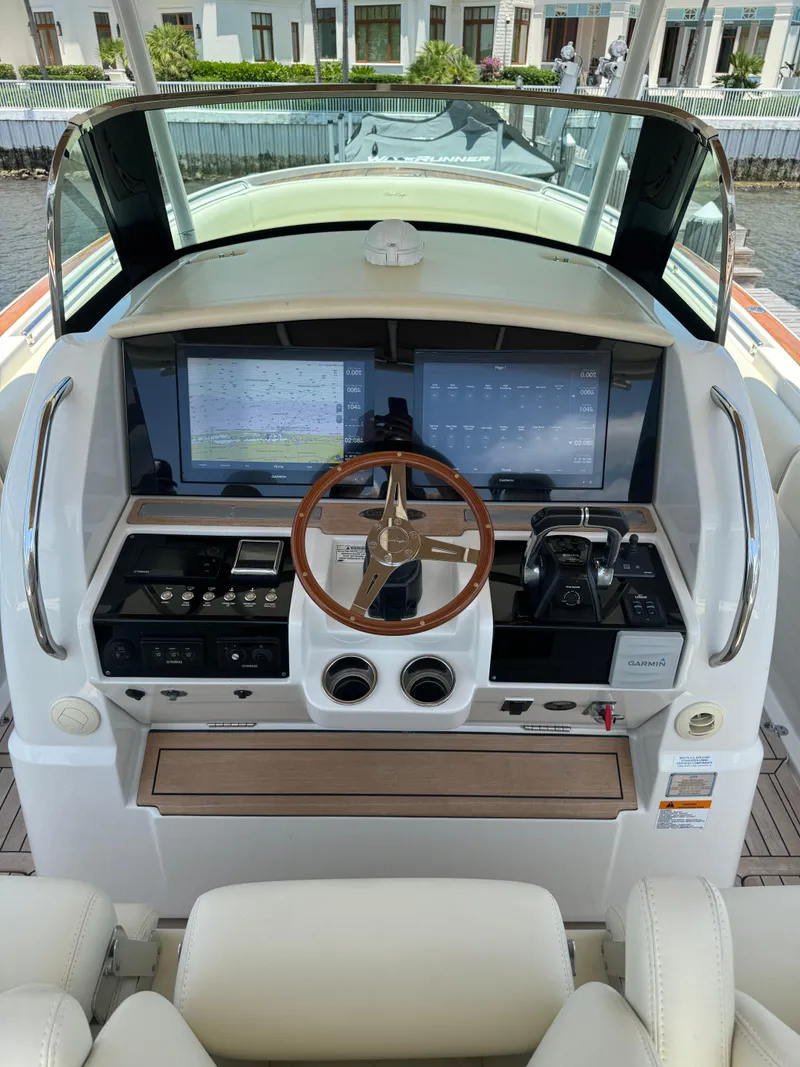 Slide: The Image of Helm of 2016 Chris-Craft Catalina 34 with modern navigation systems and wooden steering wheel. - 4