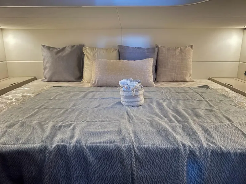 Slide: The Image of Luxurious bedroom in 2023 Fairline F//Line 33 Outboard yacht with neatly arranged pillows and towels. - 14