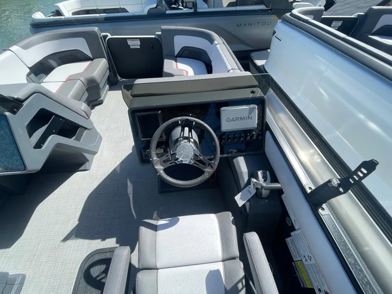Slide: The Image of 2024 Manitou Cruise boat interior with Garmin navigation system and modern seating. - 4