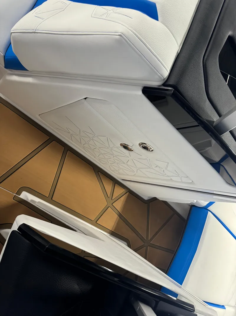 Slide: The Image of 2025 Nautique Super Air Nautique G25 Paragon interior with white and blue seating. - 15
