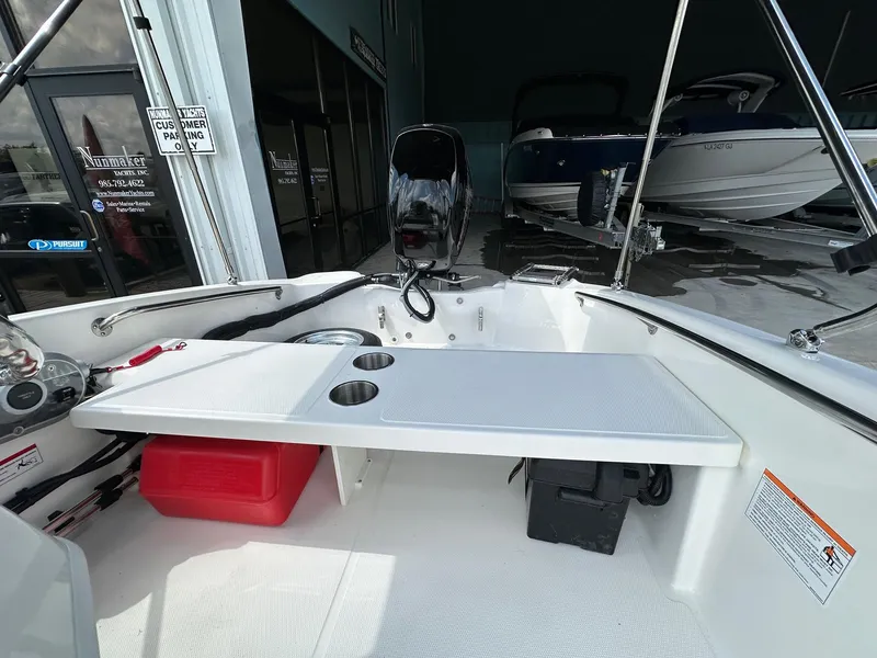 Slide: The Image of 2024 Boston Whaler 130 Super Sport interior with seating and storage compartments. - 11