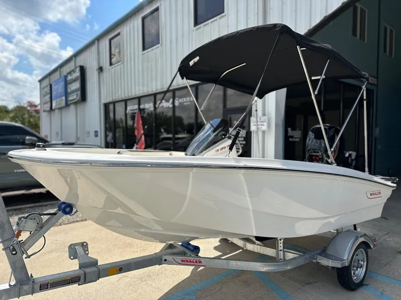 Slide: The Image of 2024 Boston Whaler 130 Super Sport boat on trailer outside dealership. - 3