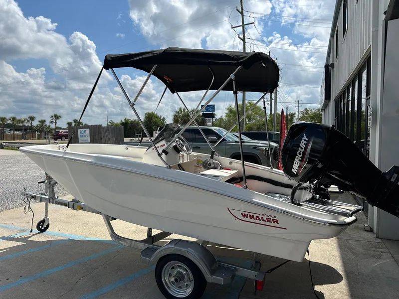 Slide: The Image of 2024 Boston Whaler 130 Super Sport boat on trailer with Mercury outboard motor. - 4