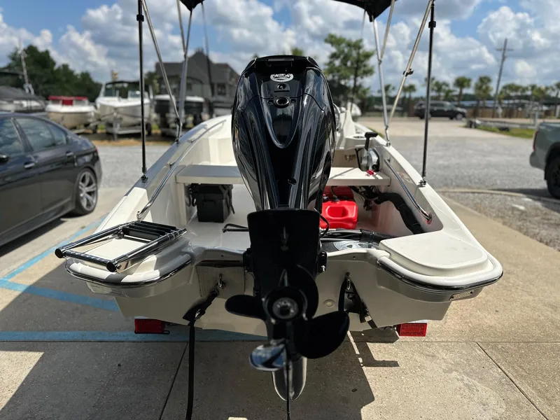 Slide: The Image of 2024 Boston Whaler 130 Super Sport boat, rear view with outboard motor, parked on a sunny day. - 5