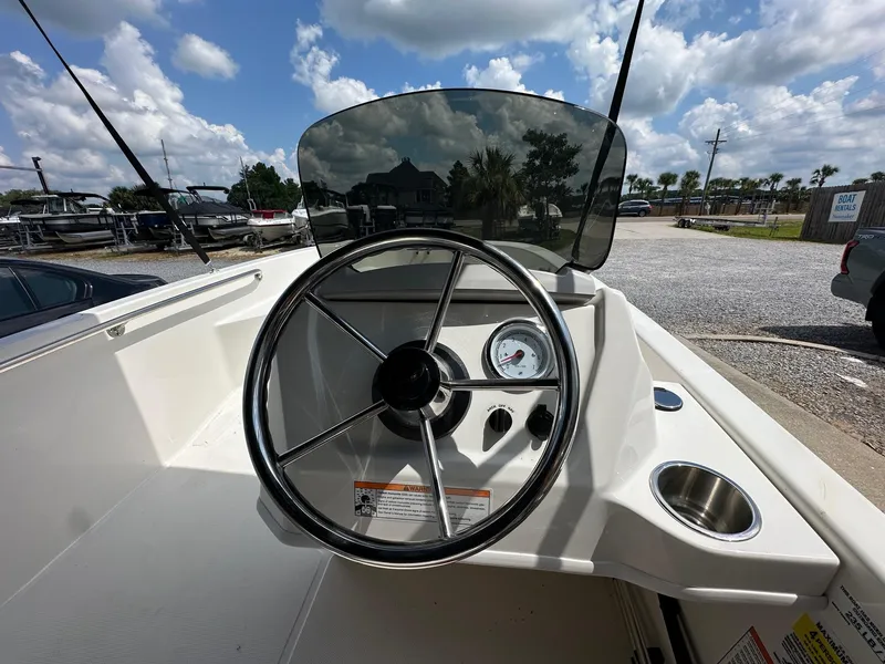 Slide: The Image of 2024 Boston Whaler 130 Super Sport boat dashboard with steering wheel and gauge. - 7