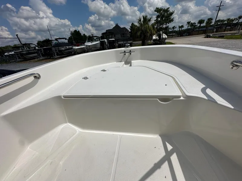 Slide: The Image of 2024 Boston Whaler 130 Super Sport boat interior with white deck and storage compartment. - 8