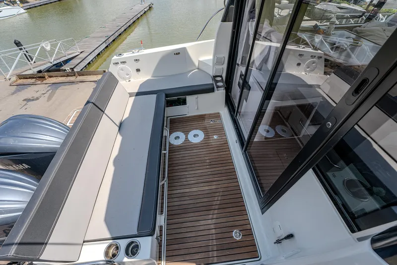 Slide: The Image of 2021 Jeanneau NC Weekender 1095 boat deck with seating and sliding glass doors. - 16