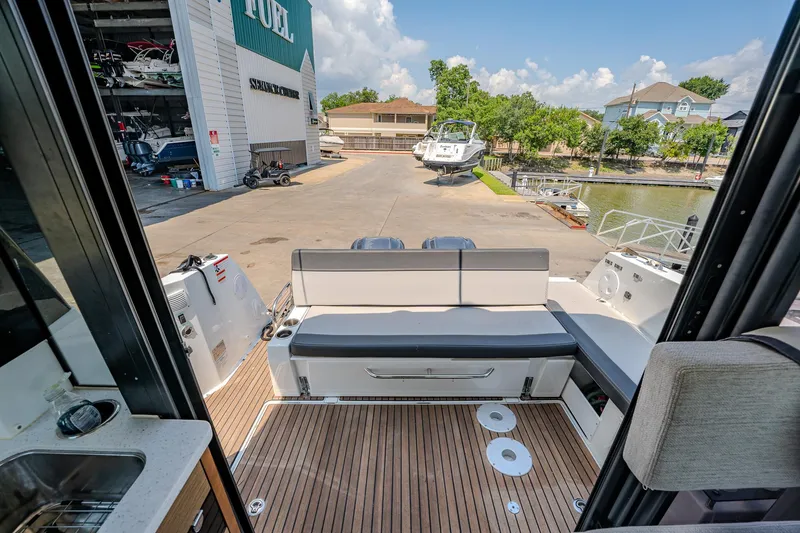 Slide: The Image of 2021 Jeanneau NC Weekender 1095 boat interior with rear seating and dock view. - 18