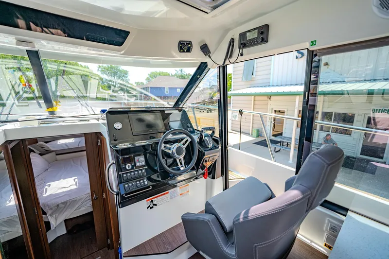 Slide: The Image of 2021 Jeanneau NC Weekender 1095 helm station with modern controls and comfortable seating. - 25