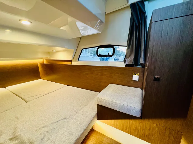 Slide: The Image of 2021 Jeanneau NC Weekender 1095 cabin interior with modern wood finish and cozy bedding. - 28