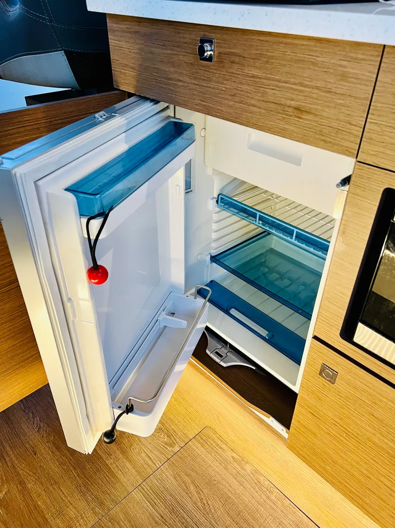 Slide: The Image of Open refrigerator in the 2021 Jeanneau NC Weekender 1095 boat kitchen. - 34