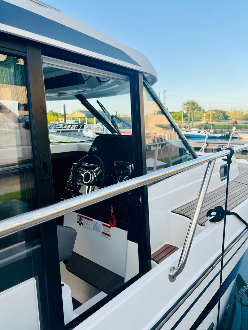 Slide: The Image of 2021 Jeanneau NC Weekender 1095 boat docked, showing cockpit and steering wheel. - 7