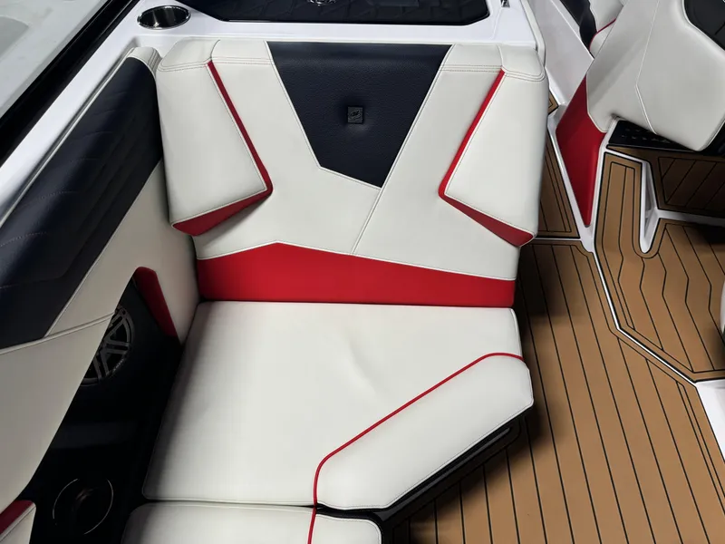 Slide: The Image of 2025 Nautique Super Air S25 interior with red and white seating and teak flooring. - 11