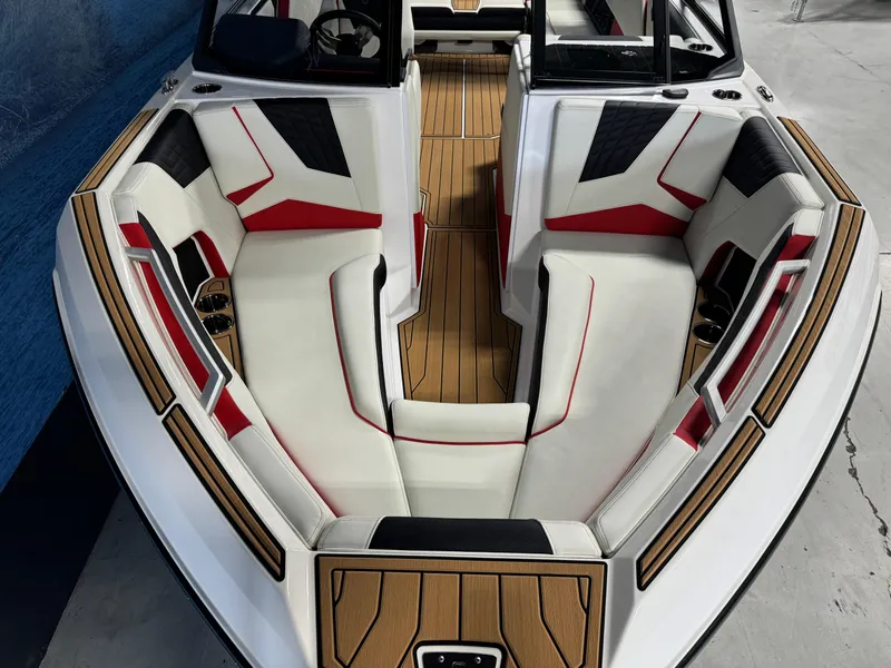 Slide: The Image of 2025 Nautique Super Air S25 boat interior with stylish seating and wood accents. - 15