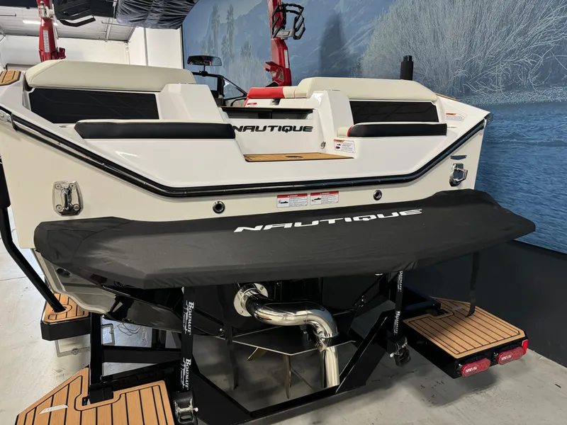 Slide: The Image of 2025 Nautique Super Air S25 boat rear view in showroom setting. - 4