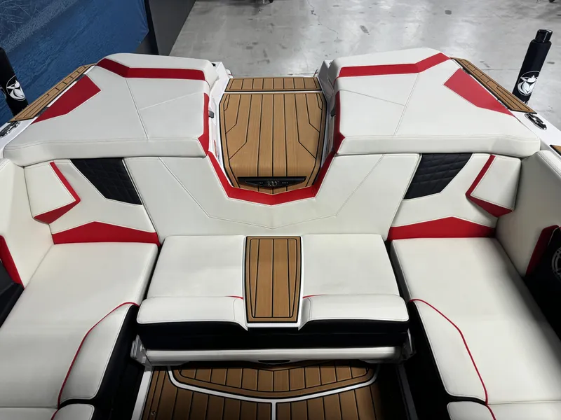 Slide: The Image of 2025 Nautique Super Air S25 boat interior with red and white seating and teak flooring. - 6