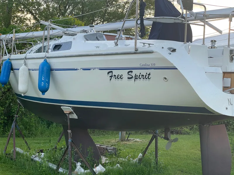 Slide: The Image of Catalina 310 sailboat named "Free Spirit" on stands, year 2000, with blue fenders. - 12
