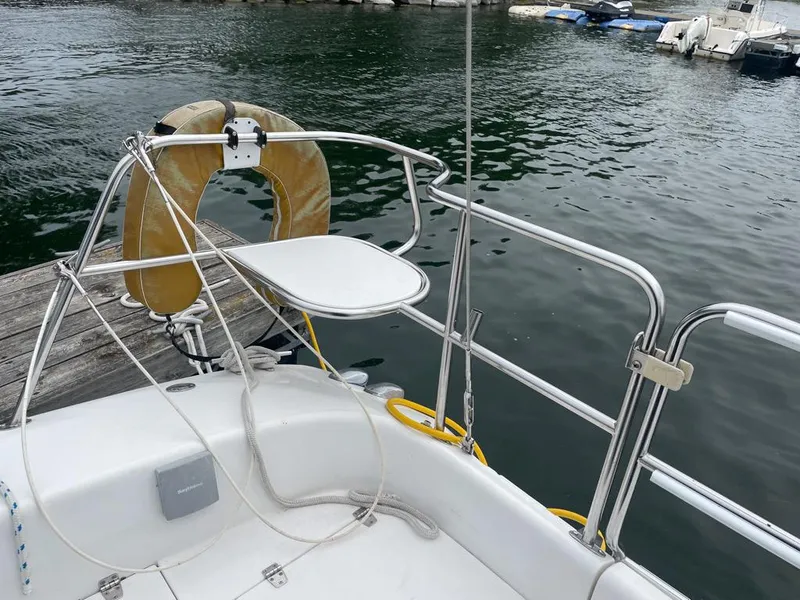 Slide: The Image of Catalina 310 sailboat deck with life preserver, docked by the water, 2000 model. - 14