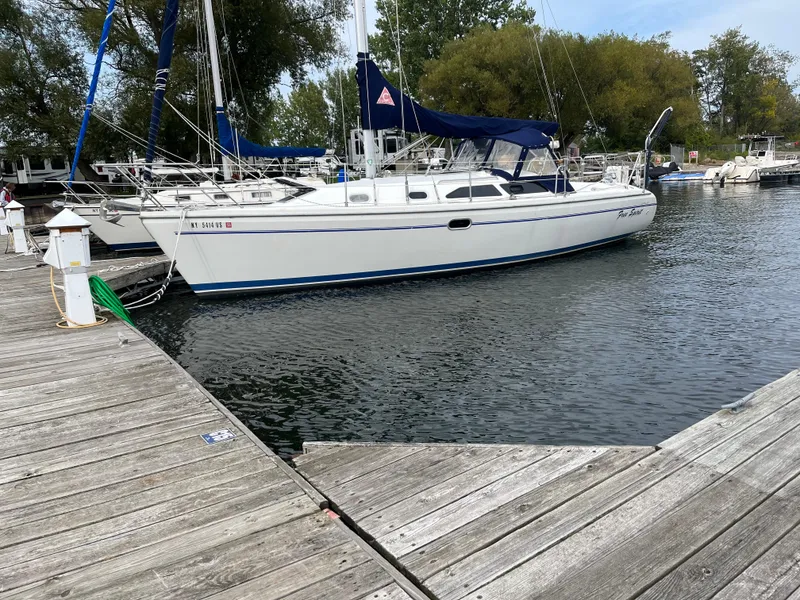 Slide: The Image of Catalina 310 sailboat from 2000 docked at a marina with trees in the background. - 2