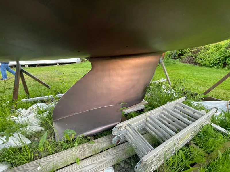 Slide: The Image of Keel of a 2000 Catalina 310 sailboat on grass with ladders nearby. - 22