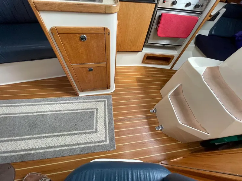 Slide: The Image of Interior of a 2000 Catalina 310 sailboat with wood flooring and compact kitchen area. - 27