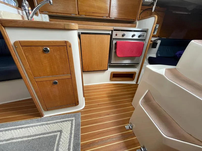 Slide: The Image of Catalina 310 yacht kitchen interior, wood cabinetry, stove, and sink, 2000 model. - 29