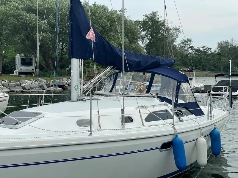 Slide: The Image of Sailboat Catalina 310, 2000 model, docked with blue fenders and canopy. - 3