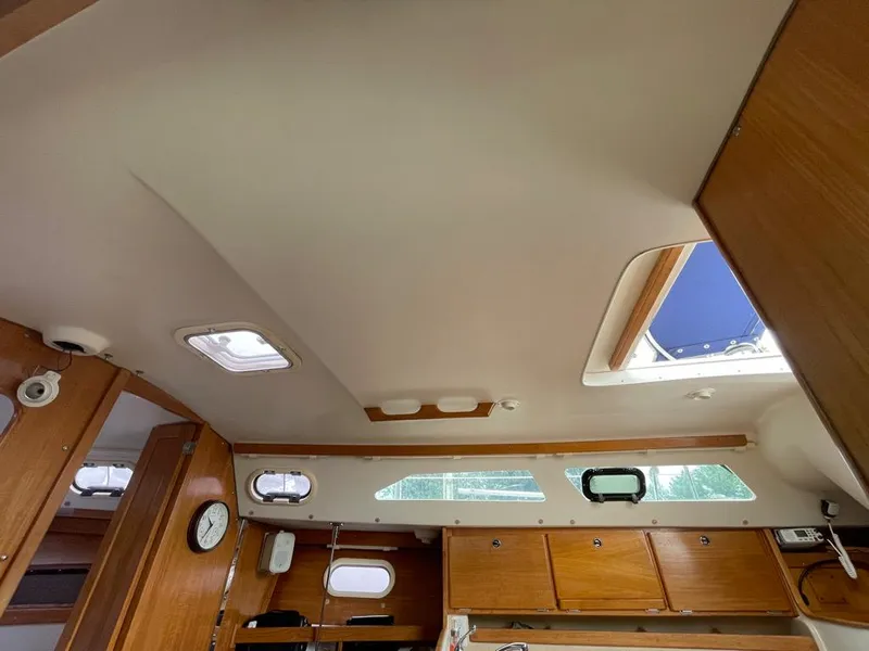Slide: The Image of Interior of 2000 Catalina 310 sailboat with wooden cabinets and ceiling hatches. - 30