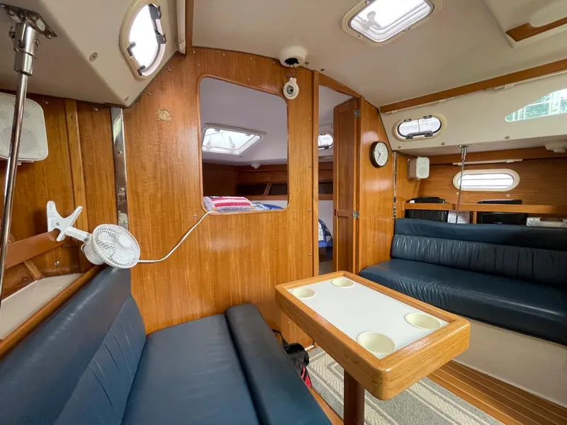 Slide: The Image of Interior of 2000 Catalina 310 sailboat with wood paneling and blue seating. - 31