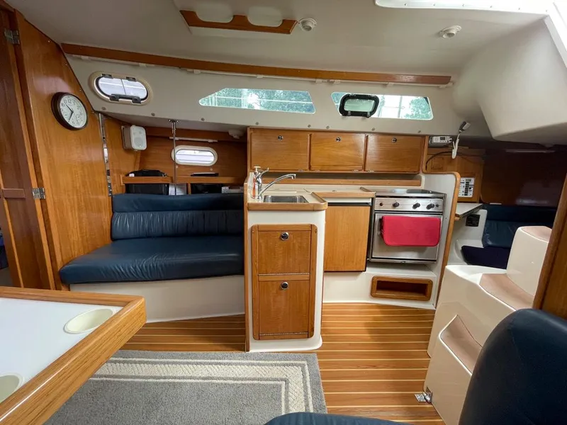 Slide: The Image of Interior of a 2000 Catalina 310 sailboat with wood cabinetry and seating. - 32