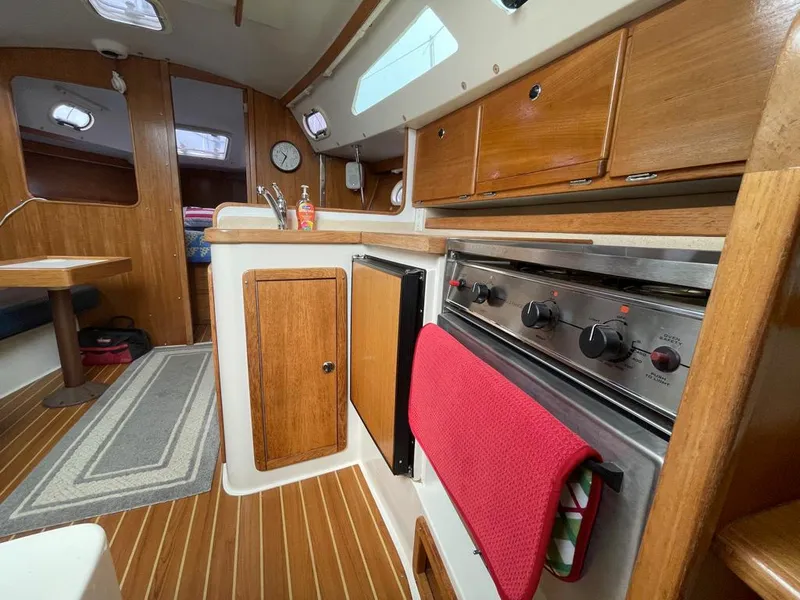 Slide: The Image of Interior of a 2000 Catalina 310 sailboat with wooden cabinetry and compact kitchen. - 34
