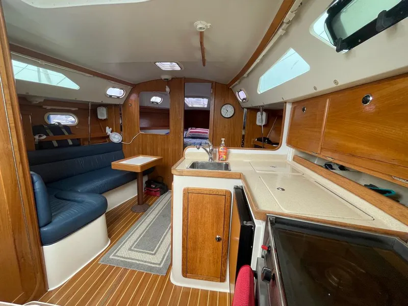 Slide: The Image of Interior of a 2000 Catalina 310 sailboat with wood finish and cozy seating area. - 35
