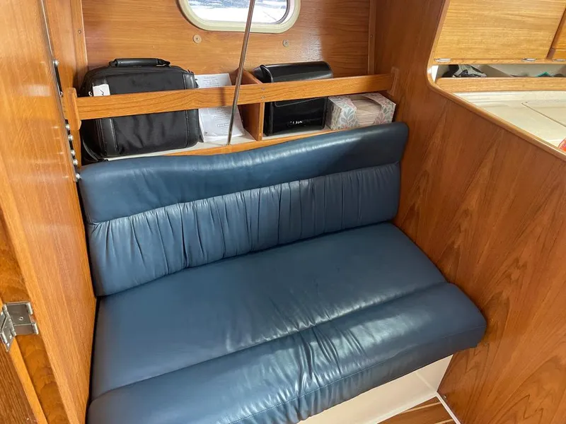 Slide: The Image of Cozy seating area in 2000 Catalina 310 sailboat with blue cushions and wooden interior. - 37