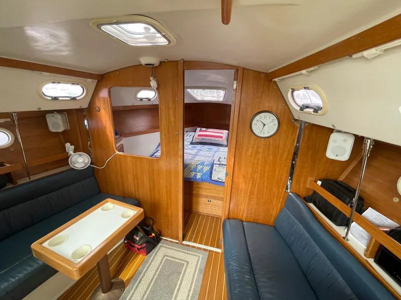 Slide: The Image of Interior of a 2000 Catalina 310 sailboat with wood paneling and cozy seating area. - 42
